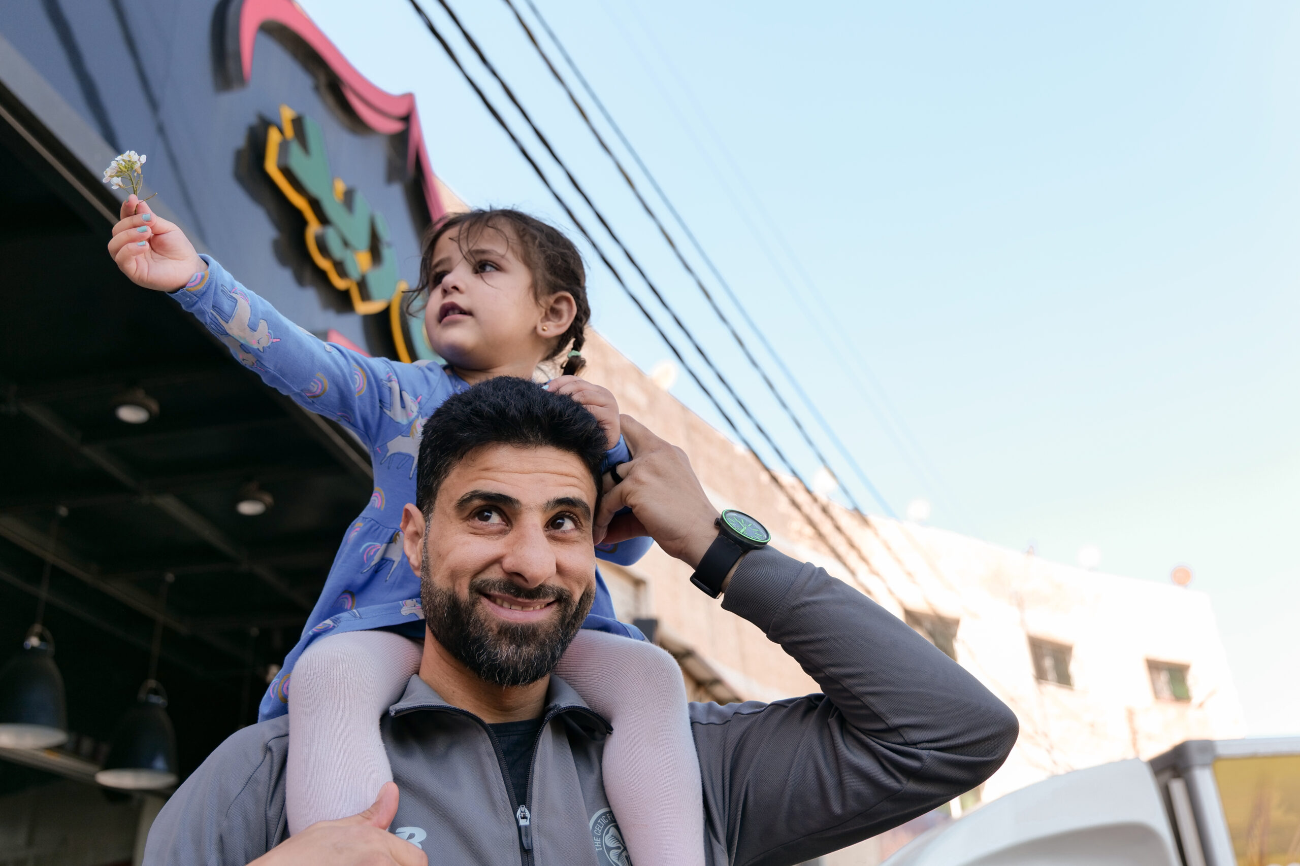 Father carrying daughter on shoulders in Jordan